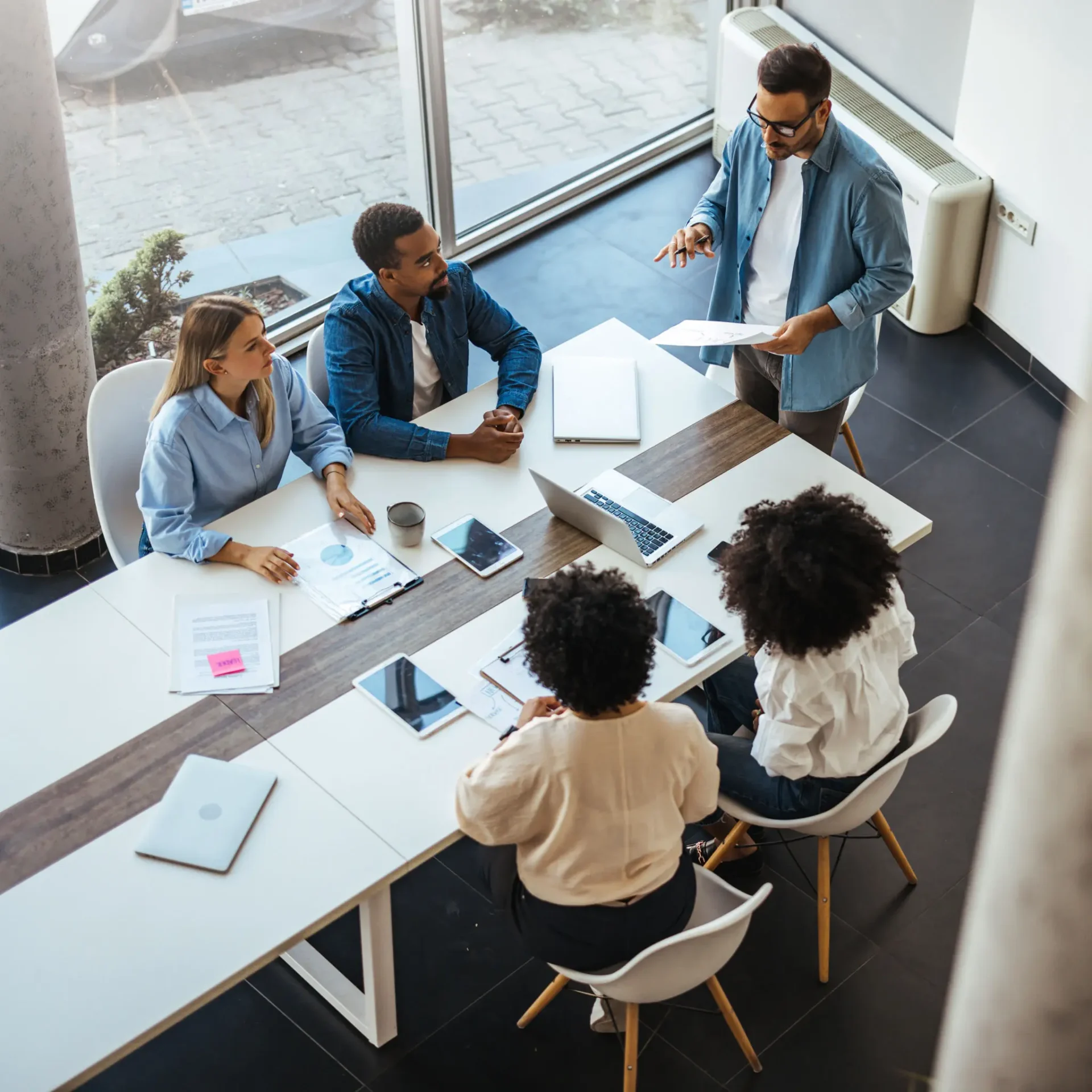 A business meeting with five professionals collaborating around a table.